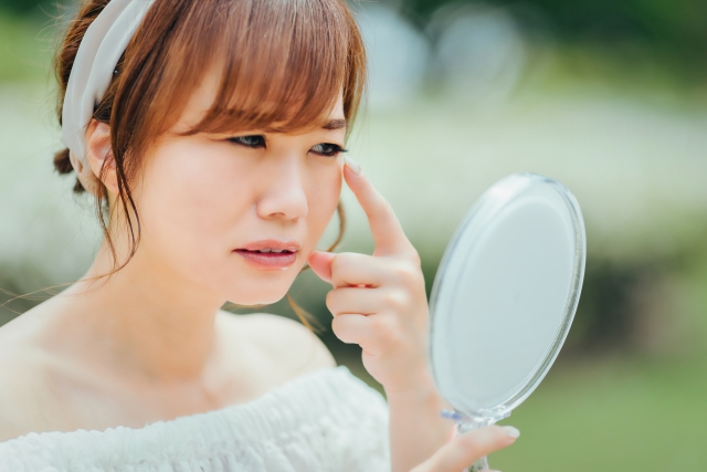 鏡で目を見る女性16