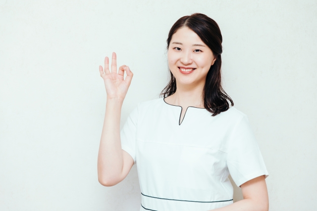 手でOKマークを作っている女性