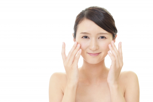頬を触って笑顔の女性