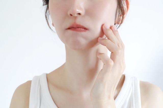 頬を触る女性